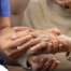 A nurse check where a patient’s hand is hurting in order to help with pain management.