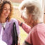 A happy caregiver enters the home of a client, representing in-home recovery care.