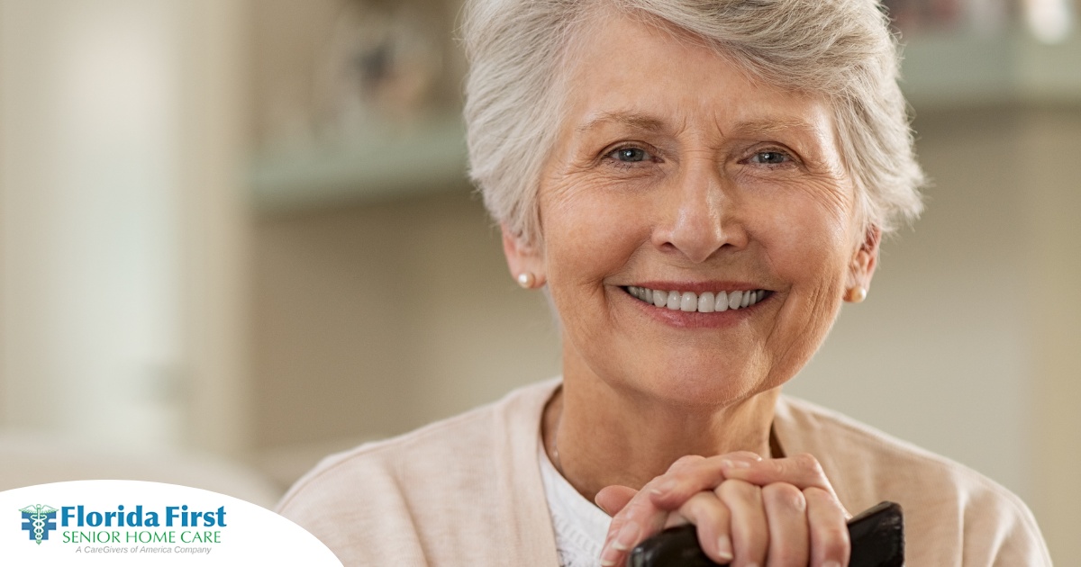 An older woman with healthy teeth smiles, representing good dental hygiene.