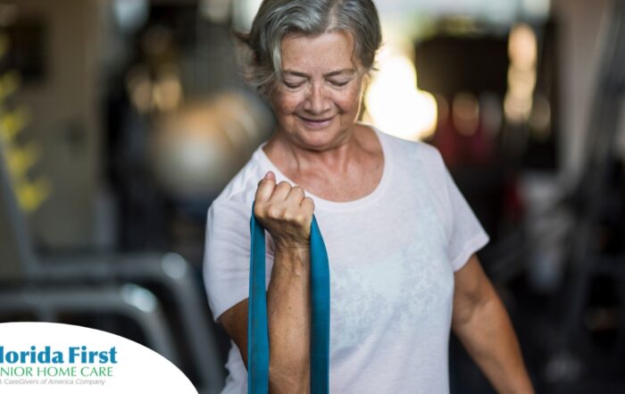 An older woman uses a resistance band to exercise, representing how staying active can help older adults keep their blood pressure in a healthy range.