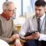 An older man talks with a doctor representing the effective communication that family caregivers should endeavor to have.